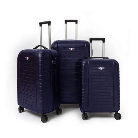 Vue d'ensemble du set de valises Pierre Cardin bleu marine, montrant les trois tailles avec leurs roulettes et poignées.