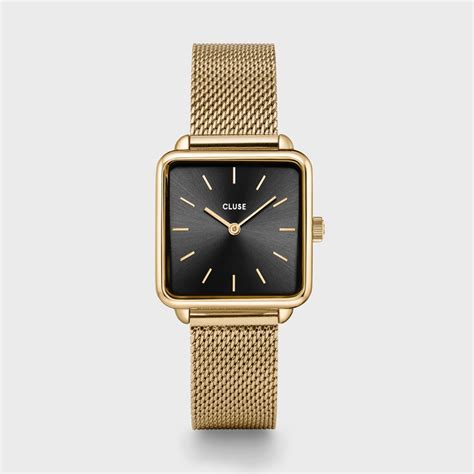 Une femme élégante portant une montre Cluse minimaliste avec un bracelet en cuir noir, dans un cadre urbain.