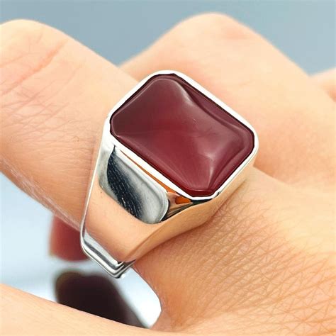 Une bague homme ornée d'une pierre rouge vive, symbolisant la passion et la force.