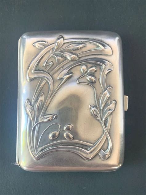 Photographie d'une élégante boîte à cigarettes Hermès en argent massif, mettant en valeur ses dimensions et son design Art Déco.