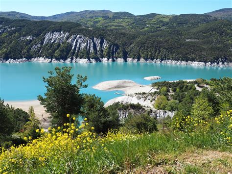 Plage du lac de Serre-Ponçon avec des eaux turquoise en automne