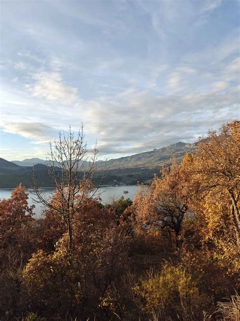 Forêt aux couleurs d'automne avec vue sur le lac de Serre-Ponçon