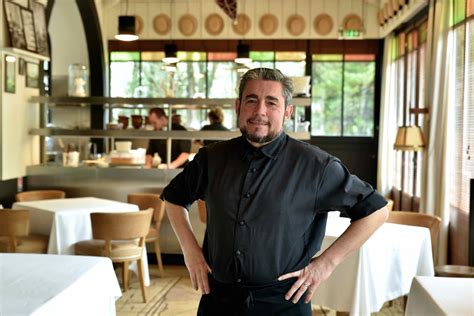 Stéphane Carrade travaillant dans sa cuisine, entouré de produits frais du terroir.