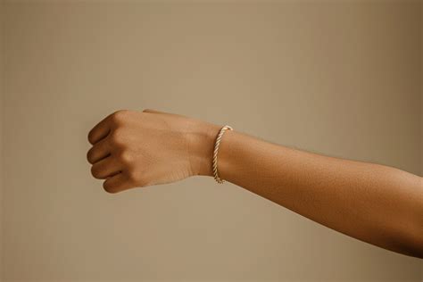 Photographie d'une femme portant un bracelet fin au poignet gauche et un bracelet plus large au poignet droit, illustrant la dualité des significations.