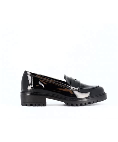 Gros plan sur un mocassin Gadea en vernis noir orné d'un bijou discret.