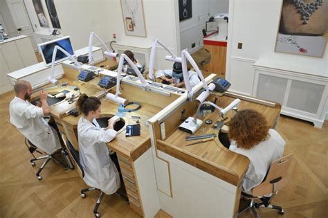 Illustration d'un atelier de haute joaillerie avec des artisans au travail, mettant en avant la minutie et l'artisanat d'art.