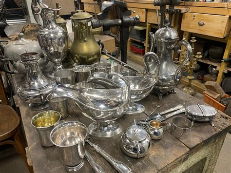 Intérieur de l'Atelier Guillot, mettant en valeur des pièces d'orfèvrerie restaurées et présentées avec soin.