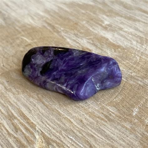 Photographie d'un spécimen brut de charoïte montrant ses inclusions et ses couleurs caractéristiques