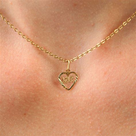 Photographie d'un pendentif cœur en or jaune simple et élégant.