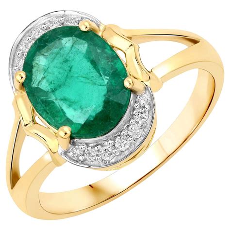 Une bague en or jaune sertie d'une émeraude et entourée de diamants