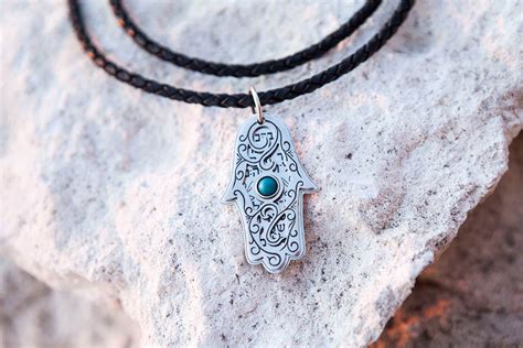 Exemple de bijou avec le symbole de la Khamsa, expliquant sa signification protectrice.