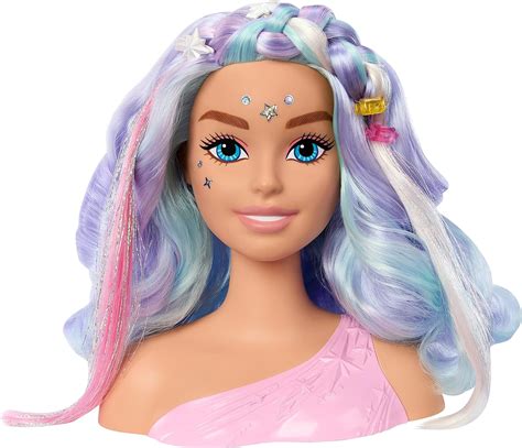 Une tête à coiffer Barbie avec des cheveux blonds et des mèches colorées pastel (rose, orange, turquoise), accompagnée d'accessoires de coiffure.
