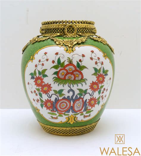 Vase décoratif en porcelaine verte et marshmallow avec motifs de cacatoès et de pinson, bordures dorées.