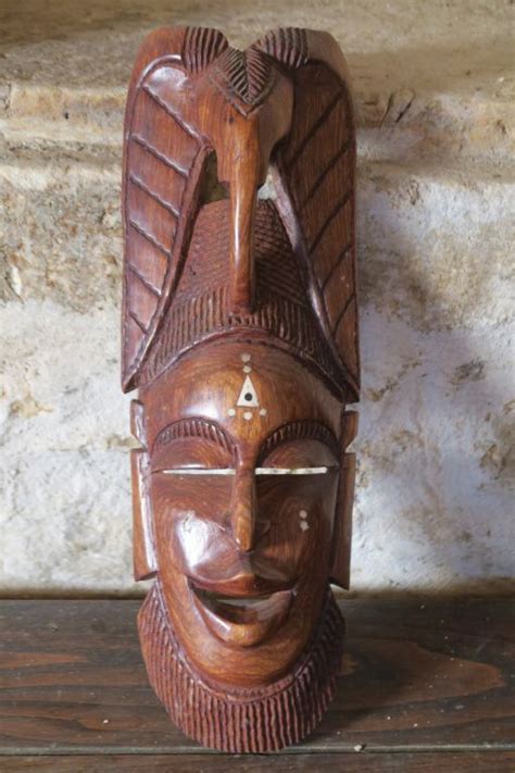 Pendentif en bois sculpté représentant un masque africain