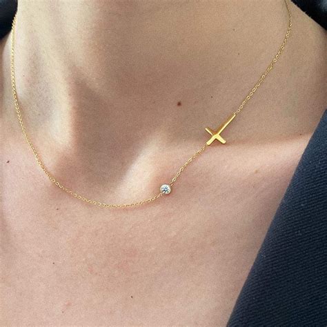 Une main tenant un collier avec un pendentif croix, symbolisant la foi.