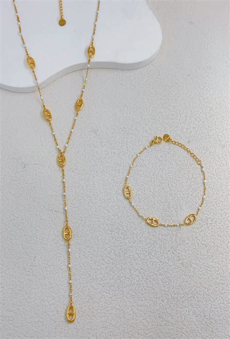 Composition de bijoux en acier inoxydable : boucles d'oreilles créoles, collier, bracelet et bague.