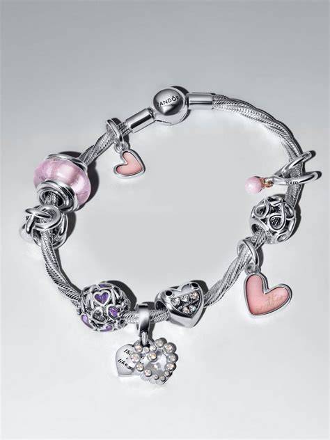 Gros plan sur des charms doubles Pandora avec des étoiles ajourées et des strass bleus et blancs.