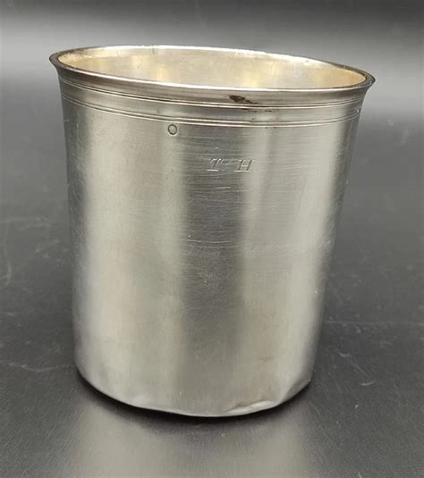 Photographie rapprochée de poinçons effacés sur une timbale ancienne, illustrant la difficulté d'identification.