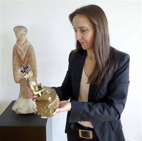 Image d'un expert examinant une sculpture bouddhique