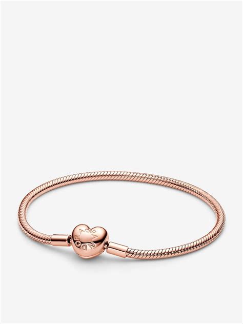 Un bracelet Pandora en or rose orné d'un fermoir en forme de cœur, avec des détails délicats.