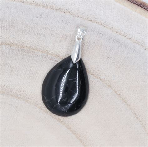 Collage de différents bijoux et objets en tourmaline noire : bracelet, pendentif, galet