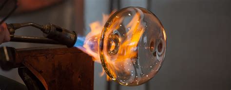 Un maître verrier travaillant le verre à la lampe pour créer des perles uniques