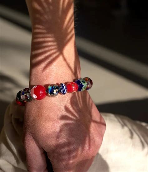 Un bracelet en perles de verre de Murano porté au poignet, mettant en avant sa finesse