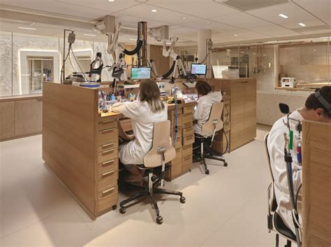Vue d'ensemble d'un atelier moderne de joaillerie, avec des employés travaillant sur différentes étapes de fabrication.
