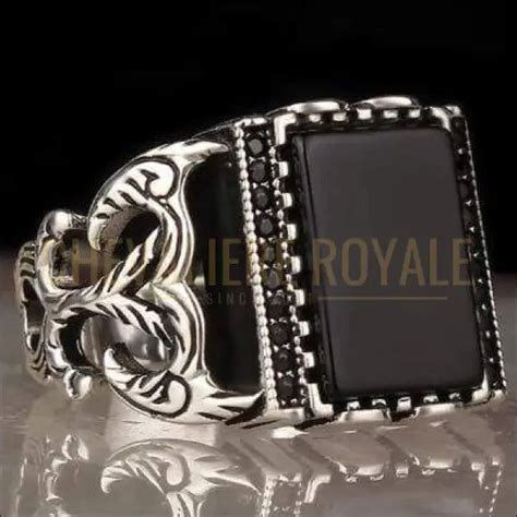 Chevalière masculine en argent rhodié avec une pierre d'onyx noir carrée au centre.