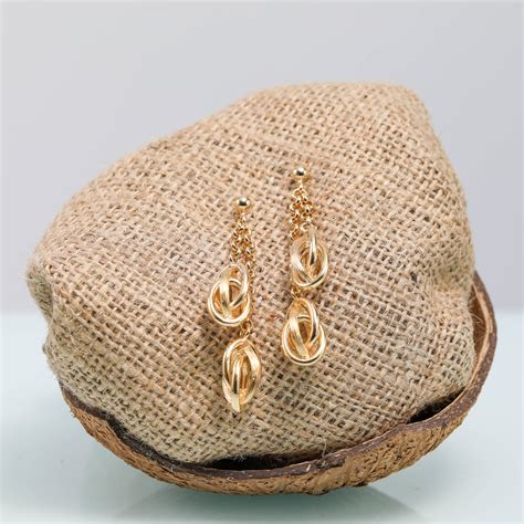 Photographie d'une parure de bijoux antillais complète (collier, bracelet, boucles d'oreilles) avec des motifs inspirés de la nature locale.