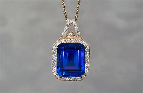 Gros plan sur un pendentif saphir bleu intense monté sur une chaîne en or