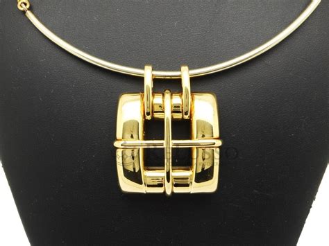 Gros plan sur un pendentif carré en or jaune 18 carats, montrant sa finition et ses dimensions.