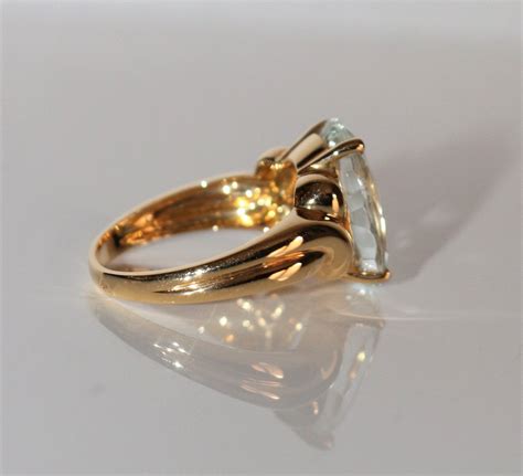 Gros plan sur une bague en or jaune sertie d'une pierre jaune