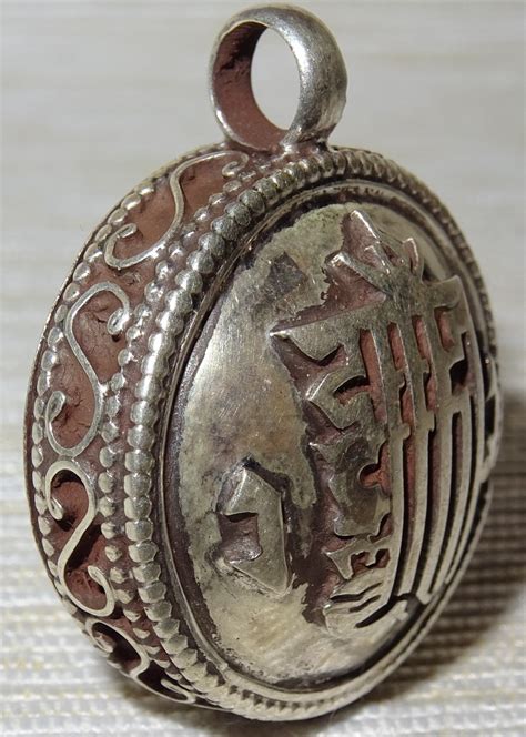 Représentation d'un Ghau, pendentif tibétain en forme de boîte, orné de symboles bouddhistes