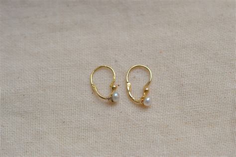 Collage de différentes boucles d'oreilles dormeuses aux styles variés : courtes, longues, avec pendentifs, colorées