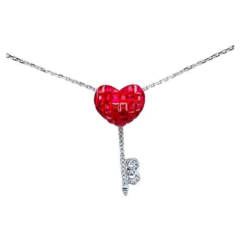 Gros plan sur un pendentif cœur en argent rose avec une rose sculptée et l'inscription 