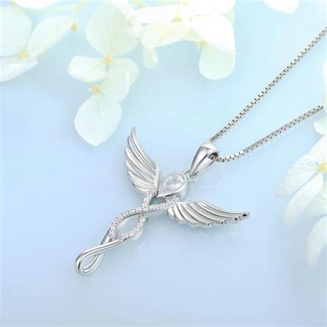 Gros plan sur un collier avec un pendentif d'ange gardien en argent et strass, et un bracelet assorti.