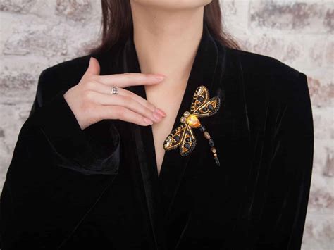 Une broche camée moderne portée sur une veste.