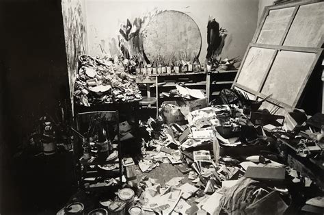 Photographie de Neil Lane dans son atelier, entouré de bijoux vintage et de croquis