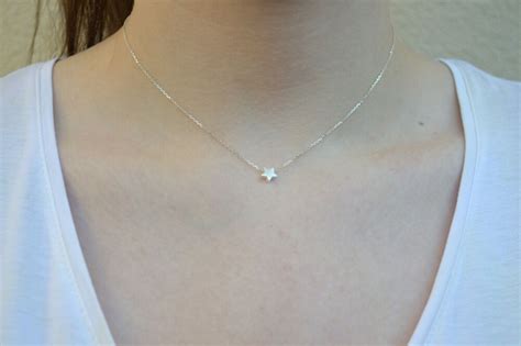 Schéma d'un collier ras de cou minimaliste avec un pendentif étoile Swarovski, montrant la chaîne et le détail du pendentif.