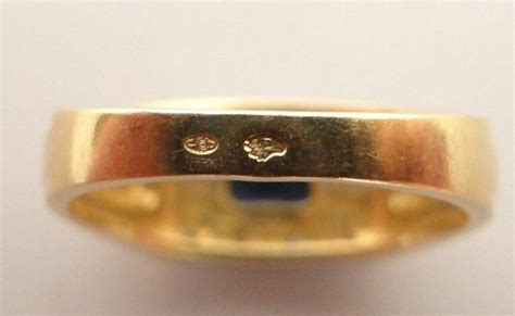 Photographie macro d'une bague moderne avec les poinçons de maître et de titre clairement visibles.