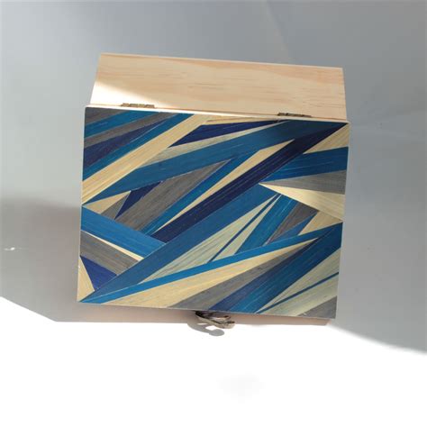 Exemple de marqueterie sur un bijou en bois, montrant l'assemblage précis de différentes essences.