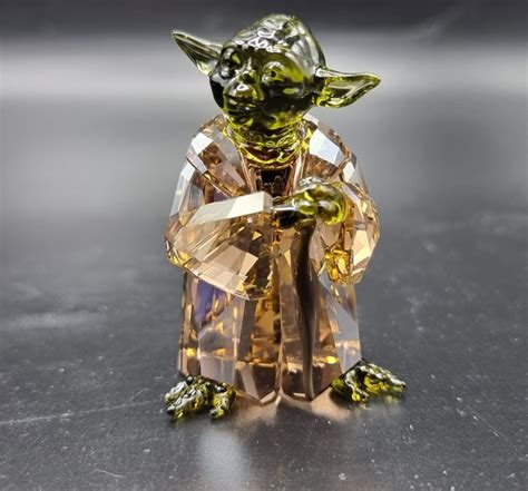 Figurine Maître Yoda en cristal Swarovski, vue de face, mettant en avant ses détails facettés et sa canne en métal.