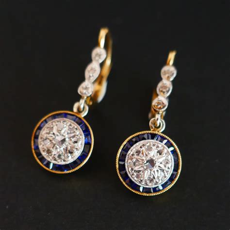 Une paire de boucles d'oreilles dormeuses Art Déco en or rose, avec un motif octogonal pavé de diamants et un grenat central de forme octogonale.