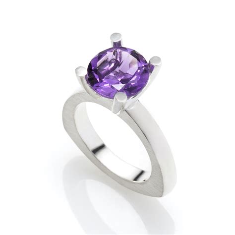 Photographie d'une bague solitaire en argent avec une améthyste centrale de taille ronde