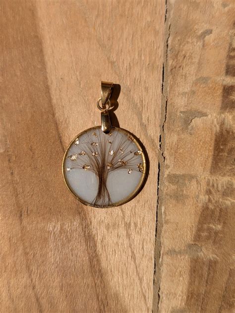 Pendentif stylisé en forme de pissenlit avec des détails de pétales et de feuilles