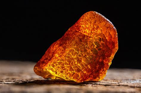 Gros plan d'une perle d'ambre brut sous loupe, montrant des inclusions naturelles et une texture organique.