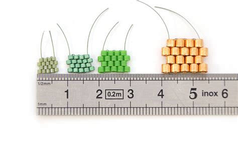 Illustration de différentes tailles de perles Miyuki Delica, mettant en évidence leur forme cylindrique et leur régularité.