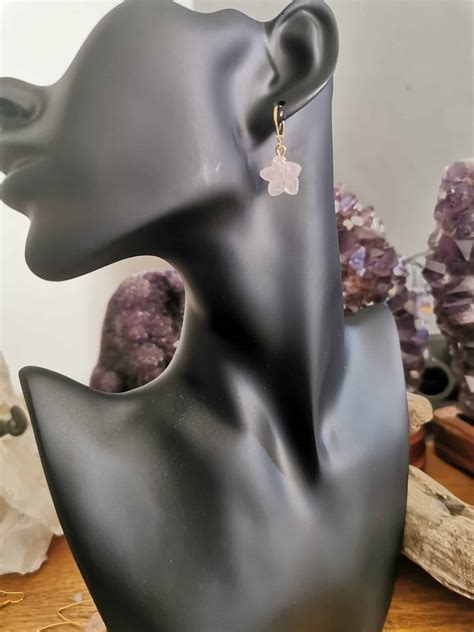 Photographie macro d'une boucle d'oreille en quartz rose polie en cabochon, mettant en évidence ses reflets doux.