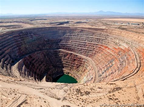 Photo d'une mine traditionnelle à ciel ouvert au Sri Lanka, avec des mineurs travaillant dans un puits.
